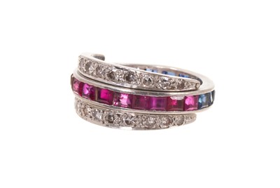 Lot 566 - Art Deco diamond, ruby and sapphire three row eternity ring with a platinum band set with calibre cut sapphires to one side and rubies to other, two hinged half bands each set with thirteen eigh...