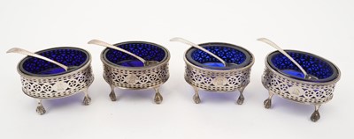 Lot 328 - Set of four Georgian oval salts on paw feet, with blue glass liners and spoons