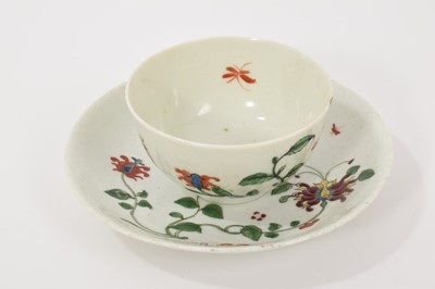 Lot 217 - A Worcester Hibiscus pattern tea bowl and saucer, circa 1758, decorated with scroll emblem, large honeysuckle flower, trailing vines and insects, the saucer 12cm diameter