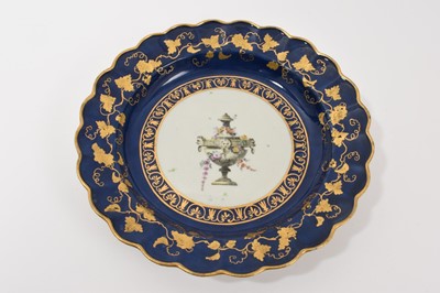 Lot 46 - A Worcester scalloped dessert plate, circa 1770, decorated in the workshop of James Giles, painted in the centre with a classical urn, draped in garlands of pink coloured flowers, rich gilt bord...