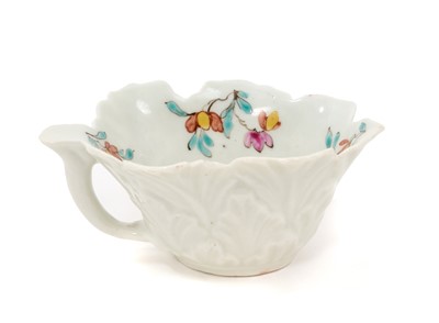 Lot 12 - A Worcester polychrome leaf-shaped butterboat, circa 1758, with branch handle, painted to the well with scattered polychrome sprigs and flowers, the exterior moulded with overlapping leaves, 8.5...
