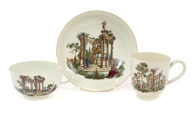 Lot 60 - A Worcester trio, comprising tea cup, coffee cup, and saucer, printed and coloured with classical ruins, gilt rims, the tea cup and saucer with crossed swords marks, the saucer 12.75cm diameter<...
