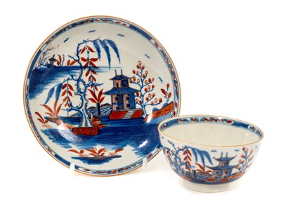 Lot 65 - A rare Worcester tea bowl and saucer, circa 1765-70, painted in the Candle Fence Pavilion pattern and clobbered at the factory, crescent marks, the saucer 12.5cm diameter