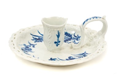 Lot 69 - A rare Worcester chamber candlestick, circa 1770, painted in blue with the Floral Sprays pattern, with scroll-moulded and pierced border, the scroll handle moulded with a mask, 15cm diameter ...