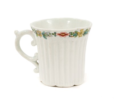 Lot 8 - An early Worcester coffee can, circa 1754-55, of elegant reeded form, with flared indented rim, bevelled base and scroll handle, the border painted with flowers in the famille verte style, 5.6cm...