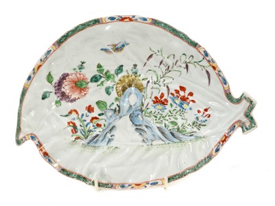 Lot 15 - A Worcester cabbage leaf dish, circa 1755-60, painted with flowers, rockwork and a moth, in the Chinese style with 'famille verte' enamels, the edge with floral panels on a diaper ground, 25.5cm...