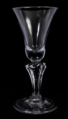 Lot 90 - A moulded pedestal stem wine glass, circa 1740, the bell bowl on a six-sided pedestal stem, over a folded conical foot, 15.8cm high