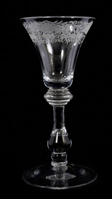 Lot 95 - A baluster wine glass, circa 1725, the bell bowl with engraved floral border, with a five-ringed annulated knop over a true baluster, on a conical foot, 16.5cm high