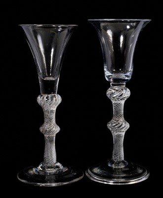 Lot 96 - Two multi series air twist wine glasses, circa 1750, both on shoulder and centre knopped stems, including one with a drawn trumpet bowl, 15.6cm high, and the other with a bell bowl and folded fo...