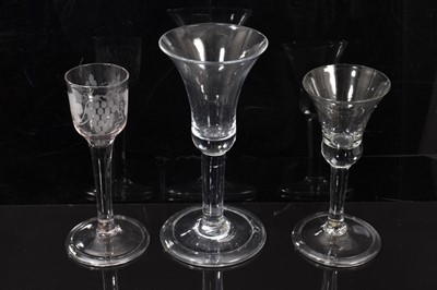 Lot 102 - Three mid 18th century wine glasses, including two with bell bowls and one with a vine-engraved ogee bowl, all on plain stems with folded feet, 14.3cm to 17.4cm high (3)