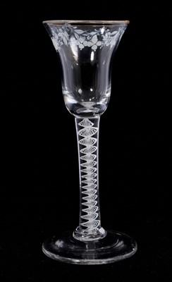 Lot 103 - A Beilby opaque twist wine glasses, circa 1765, the bell bowl decorated with gilde rim and a floral garland in white enamel, almost certainly done by Mary Beilby (1749-1797), on a single series...