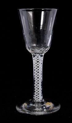 Lot 106 - A single series opaque twist wine glass, circa 1765, the round funnel bowl with spiral fluting, over a stem consisting of four multi-ply corkscrews, on a conical foot, 14.5cm high
