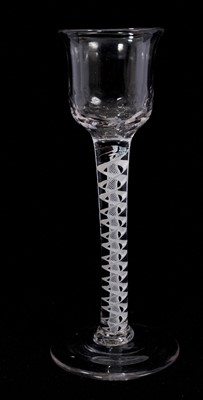Lot 109 - A cordial glass, circa 1765, the ripple-moulded ogee bowl with everted rim, on a double series opaque twist stem consisting of a pair of spiral tapes outside a vertical gauze, on a conical foot,...
