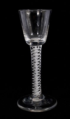 Lot 110 - A cordial glass, circa 1765, the flute-moulded round funnel bowl above a double series opaque twist stem consisting of a pair of spiral threads outside a lace twist, on a conical foot, 14.4cm hi...