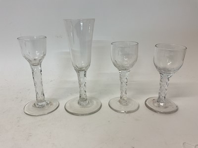 Lot 113 - Four facet cut wine and cordial glasses, circa 1780, with round funnel and ogee bowls on facet cut stems and conical feet, 12.9cm to 17.9cm high