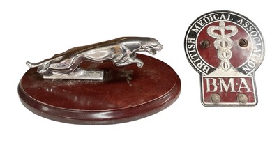 Lot 6 - Jaguar leaper car mascot, mounted on an oval wooden base, together with a British Medical Association car badge (2).