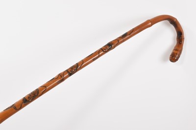 Lot 1047 - Antique Japanese bamboo walking stick, carved with mask decoration, signed