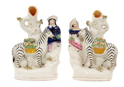 Lot 183 - Unusual pair of Staffordshire pottery zebra and child spill vases, circa 1860
