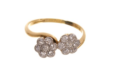Lot 674 - 1920s diamond double daisy cluster ring in platinum crossover setting on 18ct gold shank