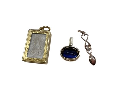 Lot 30 - Eastern religious tablet in yellow metal pendant setting, a blue stone pendant in 18ct gold setting and a 9ct rose gold Welsh love spoon pendant (3)