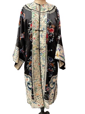 Lot 2061 - Chinese, early 20th century embroidered silk robe with front opening. Knot and loop fastenings. Silk thread embroidered flowers and symbols, sleeve bands and edgings embroidered with horses, mo...