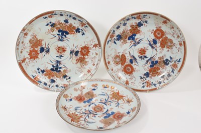 Lot 121 - A trio of large 18th century Chinese Imari porcelain dishes, painted with flowers, measuring 34.5cm, 38.5cm and 39cm diameter