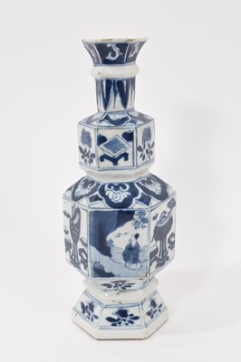 Lot 123 - A Chinese blue and white porcelain vase, Kangxi period, of hexagonal double gourd form, painted with panels containing figures and precious objects, with floral borders, 23cm high