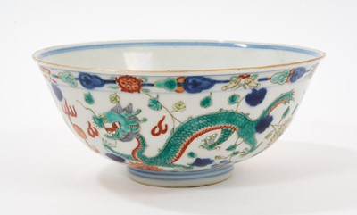 Lot 126 - A Chinese porcelain bowl, Qianlong mark to base but dates from 19th century, painted in Wucai enamels with a dragon and phoenix pattern, 15.25cm diameter