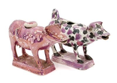 Lot 135 - Two early 19th century lustre cow creamers, including one in black and purple, and the other with purple splashes