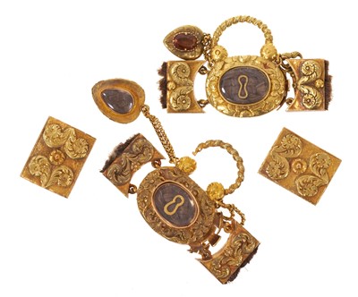 Lot 502 - A fine quality pair of Regency gold mourning bracelet clasps, each designed as a padlock with glazed components containing plaited hair and suspending a gold key and heart-shaped pendant drop wi...