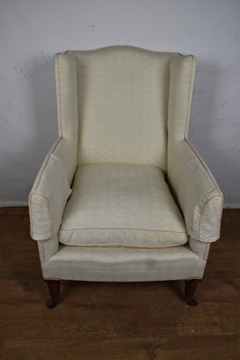 Lot 1647 - 19th century wing armchair, with cream upholstery on ring turned tapered legs and castors