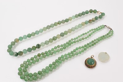 Lot 555 - Chinese jade/green hardstone double-strand necklace with two strings of graduated beads measuring 8.4-3.8mm on a diamond set-clasp, 41cm, together with a jade/hardstone heart shaped pendant and...