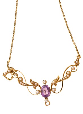 Lot 689 - Edwardian gold amethyst and seed pearl necklace with a central oval mixed cut amethyst flanked by seed pearl scrolls, on a gold chain with barrel clasp, in original fitted leather box retailed b...