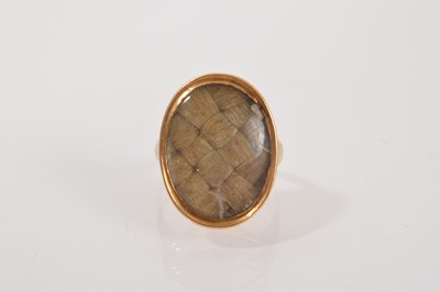 Lot 692 - George III mourning ring with an oval bezel containing a panel of plaited hair in gold setting, ring size approximately G.