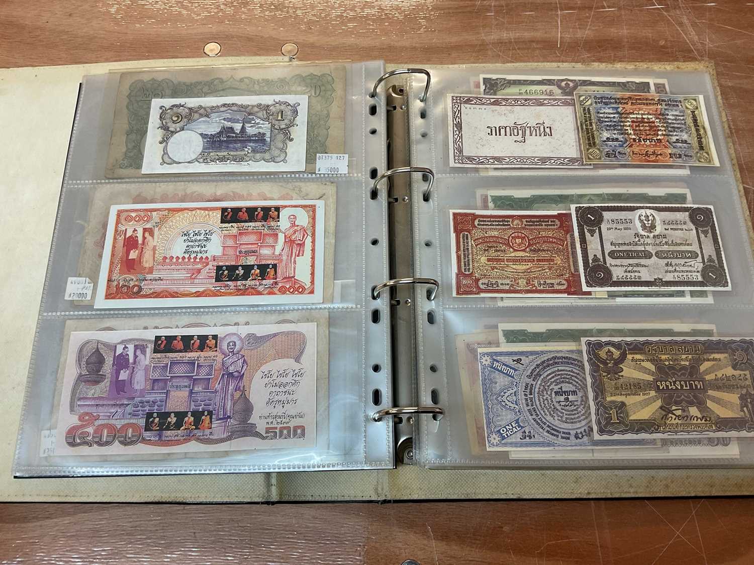 Lot 423 - Thailand - An album containing mixed banknotes to include scarcer mid 20th century issues and others (N.B. Mixed grades) (98 banknotes)