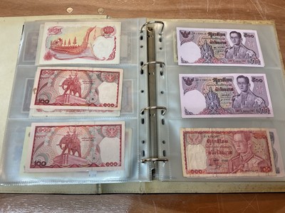 Lot 423 - Thailand - An album containing mixed banknotes to include scarcer mid 20th century issues and others (N.B. Mixed grades) (98 banknotes)