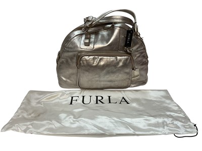 Lot 2075 - Two Furla handbags one in silver leather new with tags, the other Gold leather light use. Both have dust bags both large size. Two Issie B silver leather handbags medium and large size, both ne...
