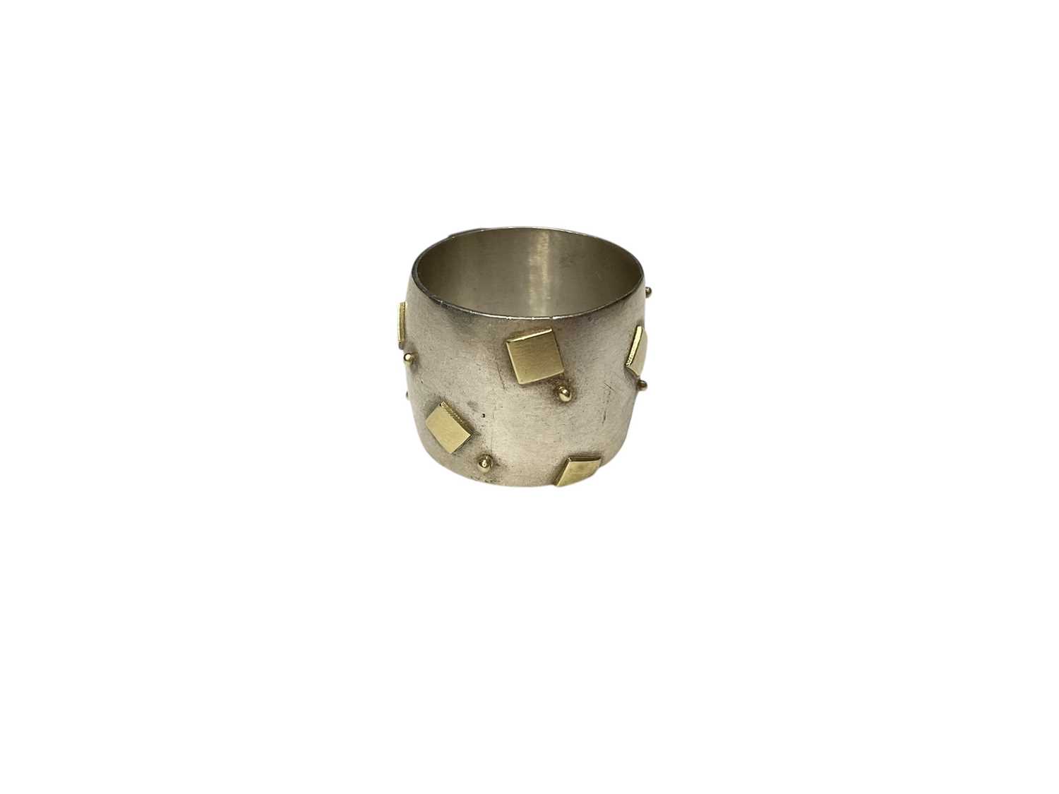 Lot 117 - Modernist silver thick band ring with applied yellow metal square and dot decoration (Dublin 2000)