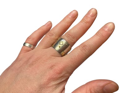 Lot 117 - Modernist silver thick band ring with applied yellow metal square and dot decoration (Dublin 2000)