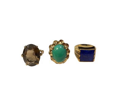 Lot 101 - Yellow metal oval smoky quartz cocktail ring, yellow metal turquoise cabochon cocktail ring and a yellow metal signet ring with a lapis lazuli square panel (3)