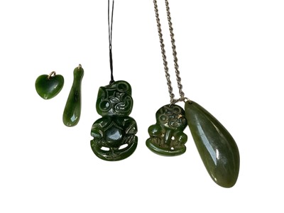 Lot 106 - Māori green hardstone tiki pendant and another green hardstone pendant on a silver chain, together with other similar pendants