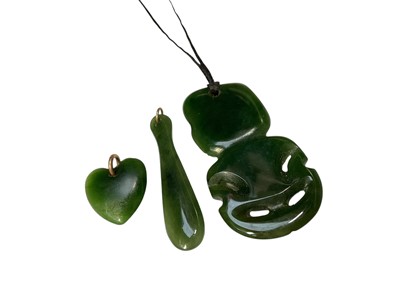 Lot 106 - Māori green hardstone tiki pendant and another green hardstone pendant on a silver chain, together with other similar pendants