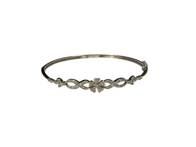 Lot 115 - 9ct white gold diamond set floral design hinged bangle