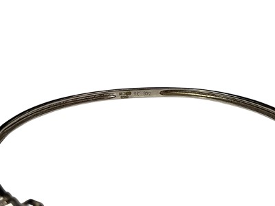 Lot 115 - 9ct white gold diamond set floral design hinged bangle