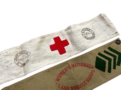 Lot 703 - First World War Army Medical Service Red Cross arm band stamped 19.11.1914 and also stamped Sussex Voluntary Aid 964, together with another Red Cross badge and a Women's National Land Service Co...