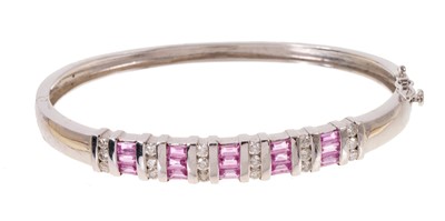 Lot 625 - 14ct white gold diamond and pink sapphire hinged bangle