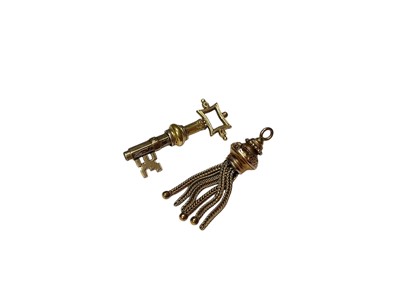 Lot 181 - Antique yellow metal winding key in the form of a key and a yellow metal tassle (2)