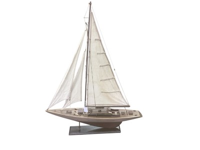 Lot 2472 - A model sailing boat. Wooden base and wooden construction, cloth made sails. Approx 99cm tall, 76cm long, the mast is 81cm tall.