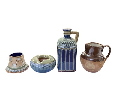 Lot 1303 - Group of Doulton stoneware to include vesta holder/striker, ashtray, decanter and a harvest jug (4)