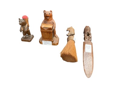 Lot 2487 - Four early to mid 20th century Black Forest bears, including a pin cushion, matchbox holder, brush, and letter opener (4)